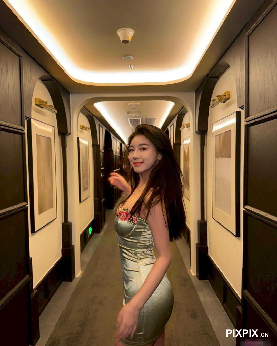 走廊里站着一个女人，手里拿着一杯酒