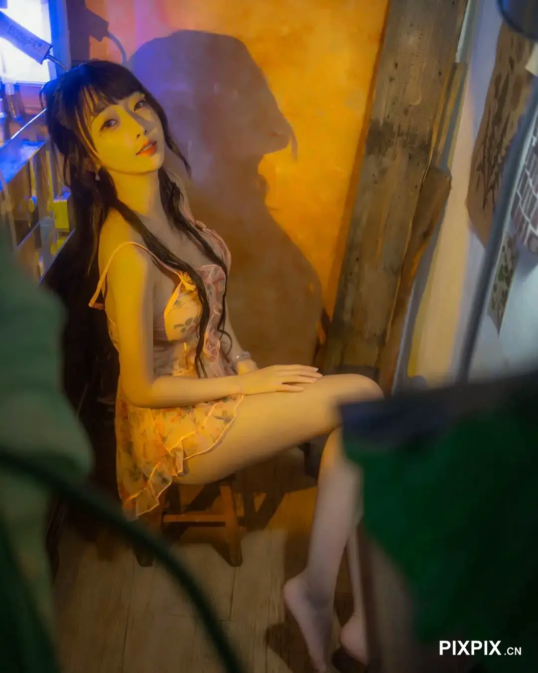 有个女人坐在椅子上，身穿黄色连衣裙