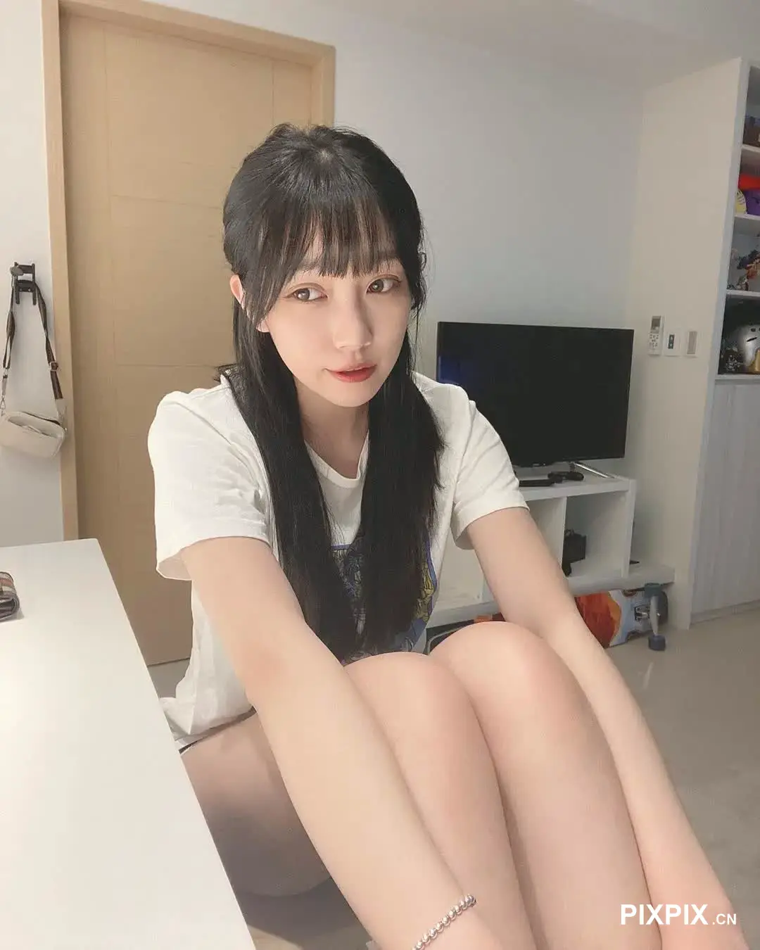 坐在床上拿着遥控器的女人