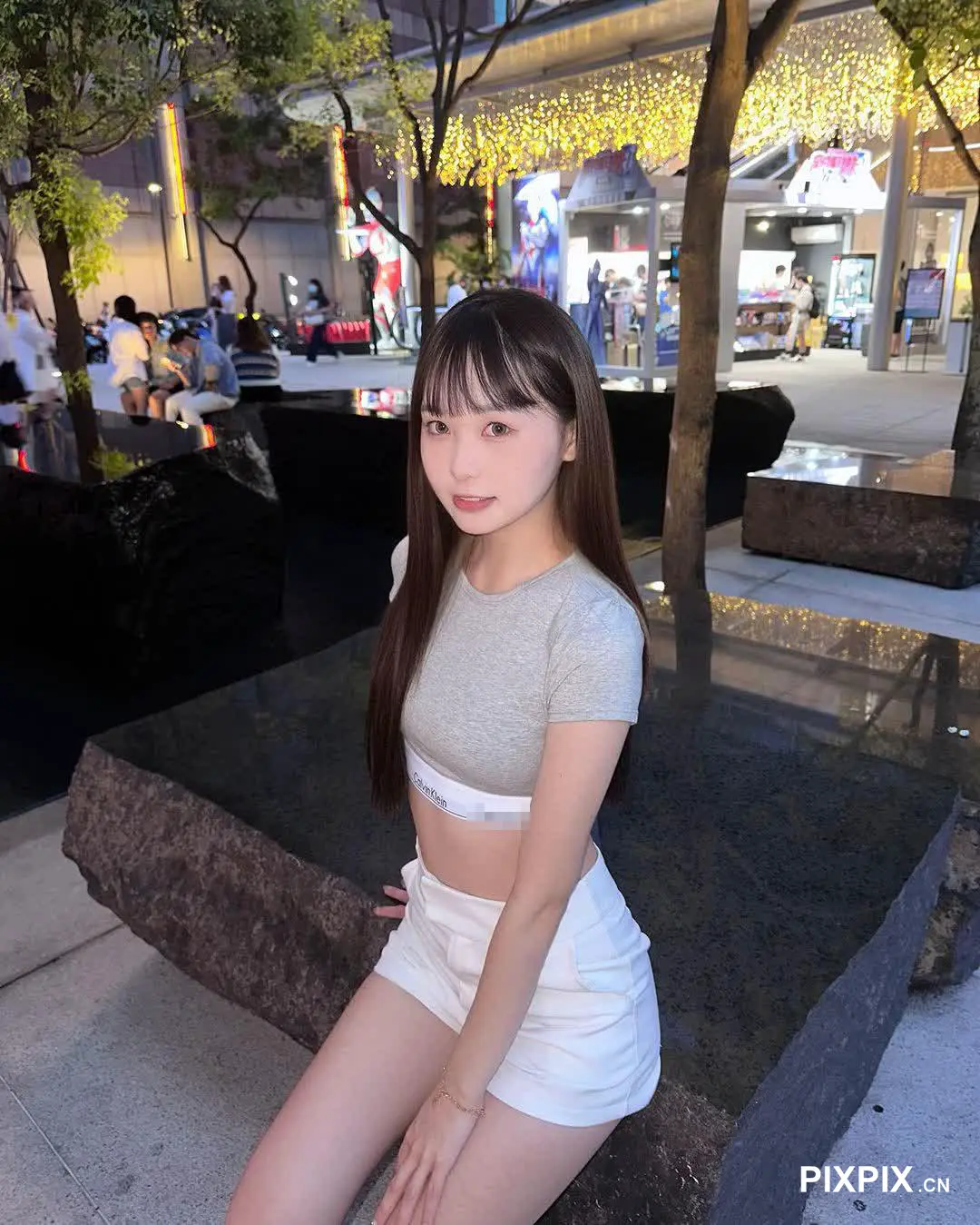 坐在城市长椅上的亚裔女性