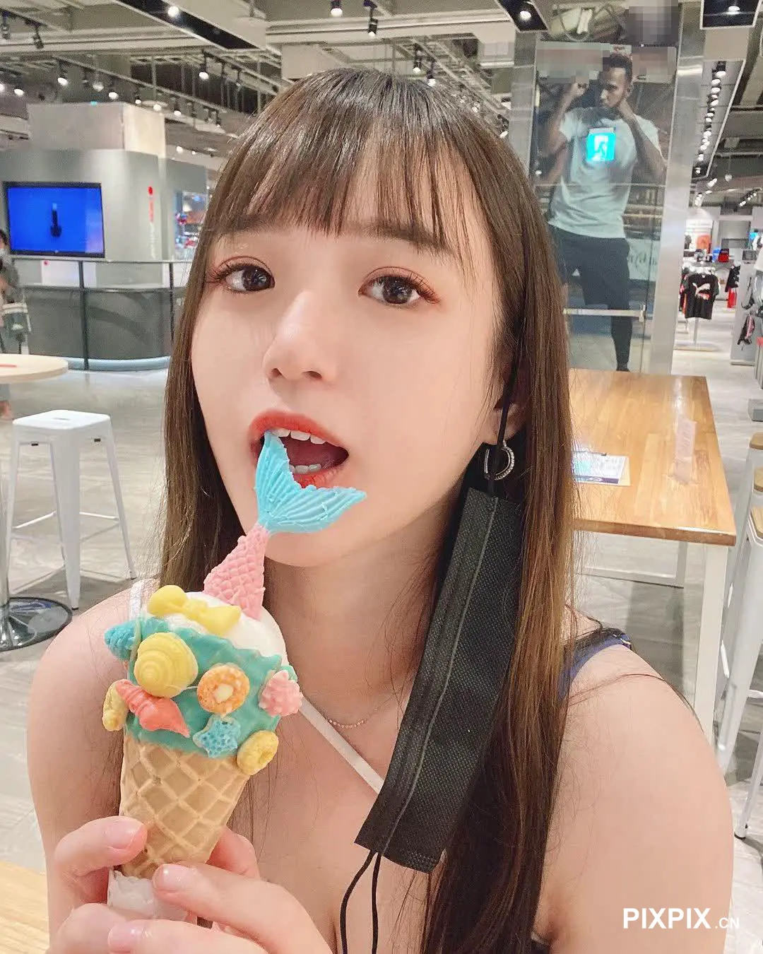 女孩用蓝色勺子吃甜筒冰淇淋