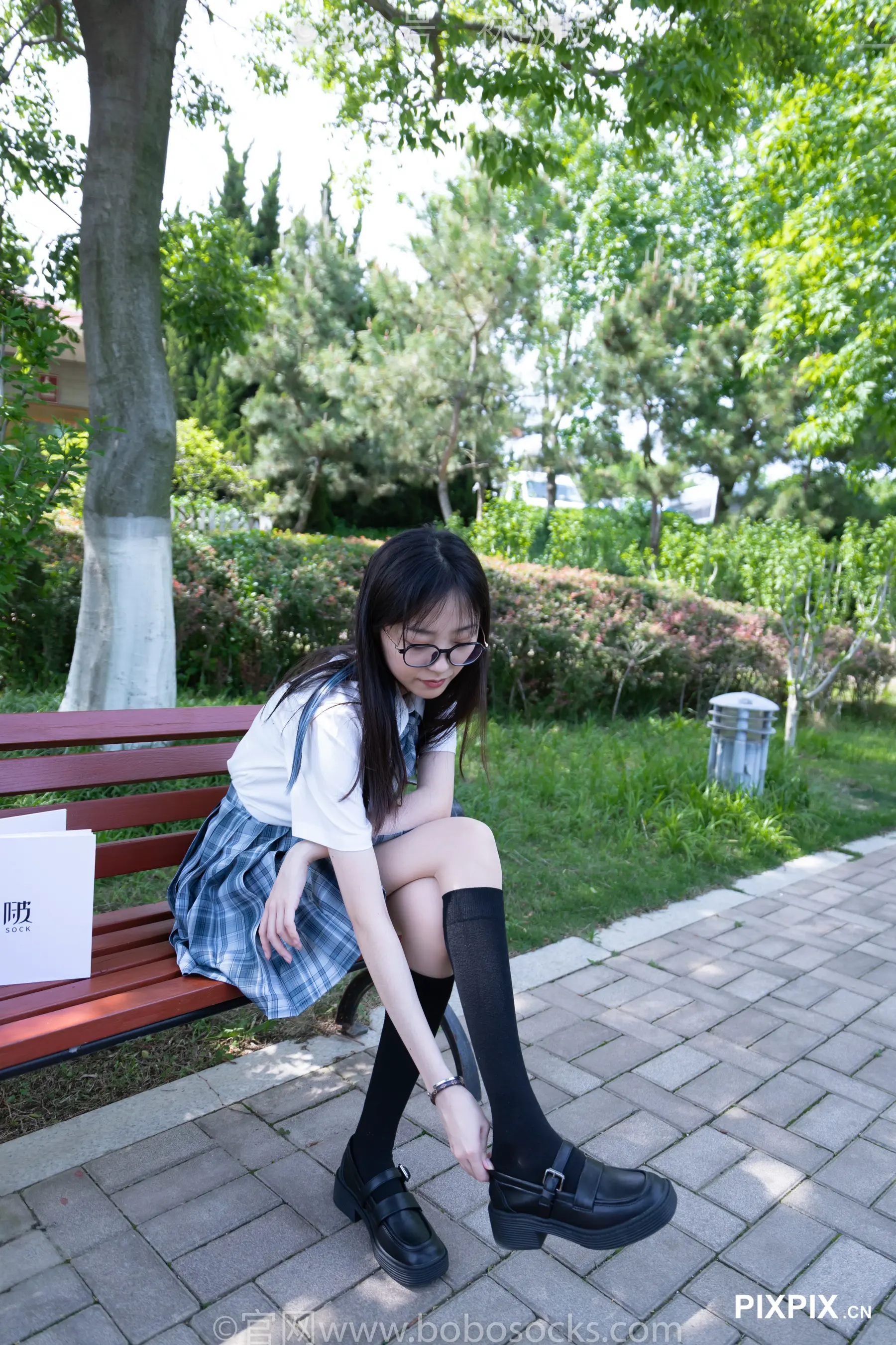 亚洲女孩坐在长凳上，上面有牌子