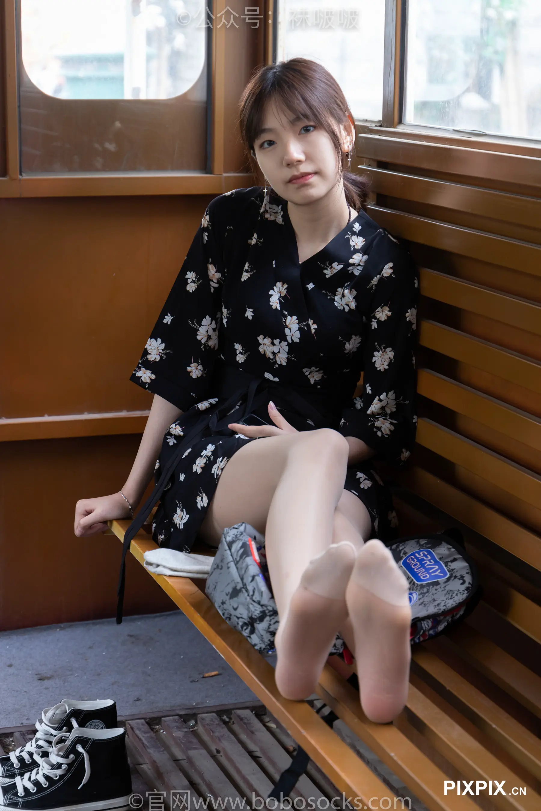 坐在长凳上，双脚抬起，穿着鞋子