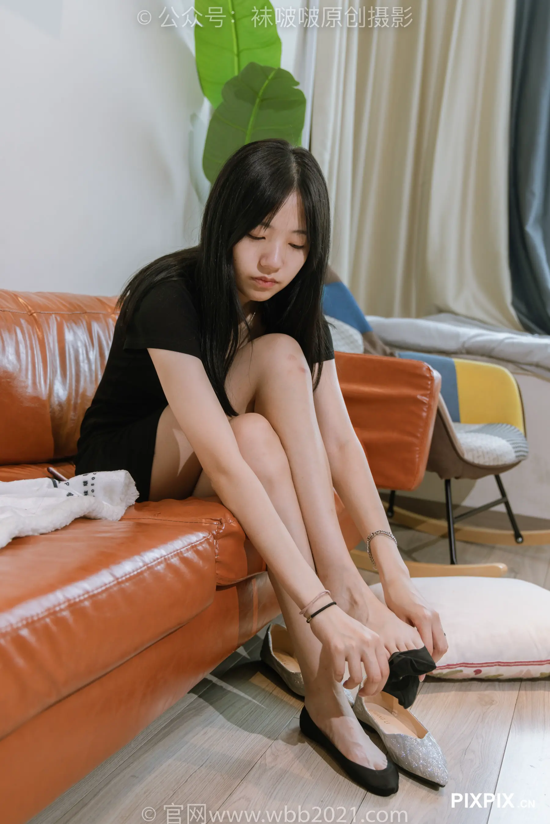 女人坐在沙发上，双脚放在书上