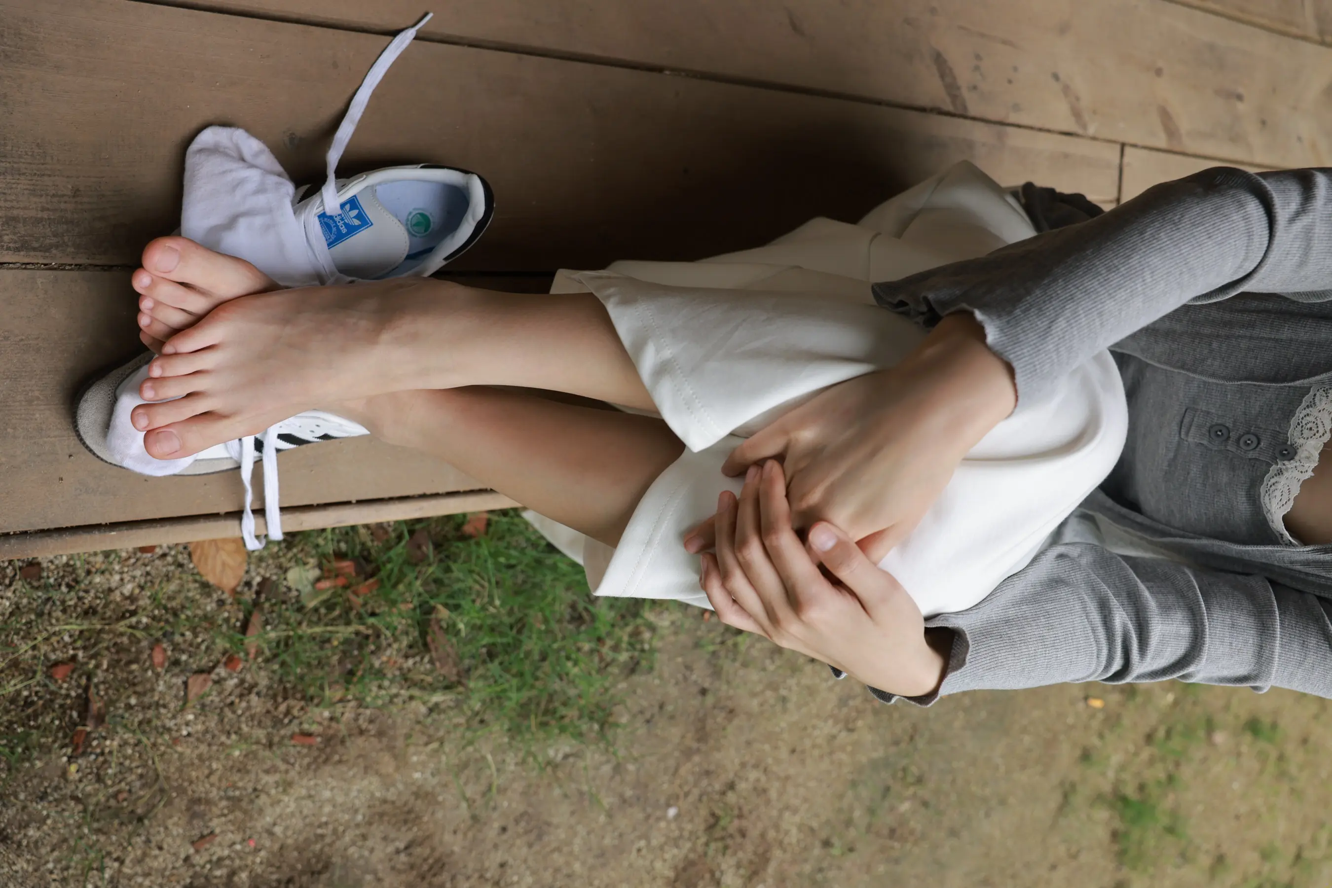 坐在长凳上双脚撑起的女人
