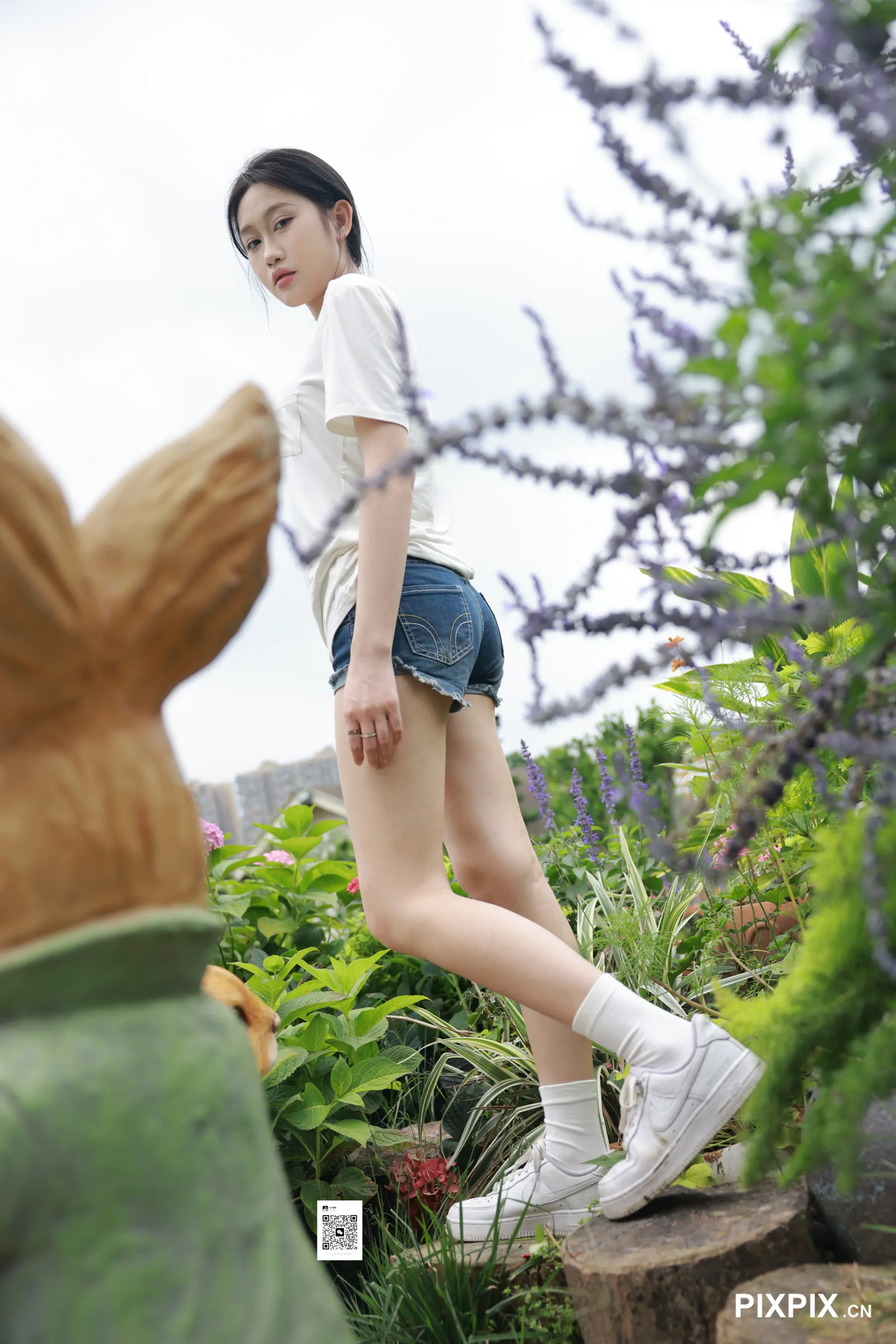 走在兔子雕像旁边的木桩上