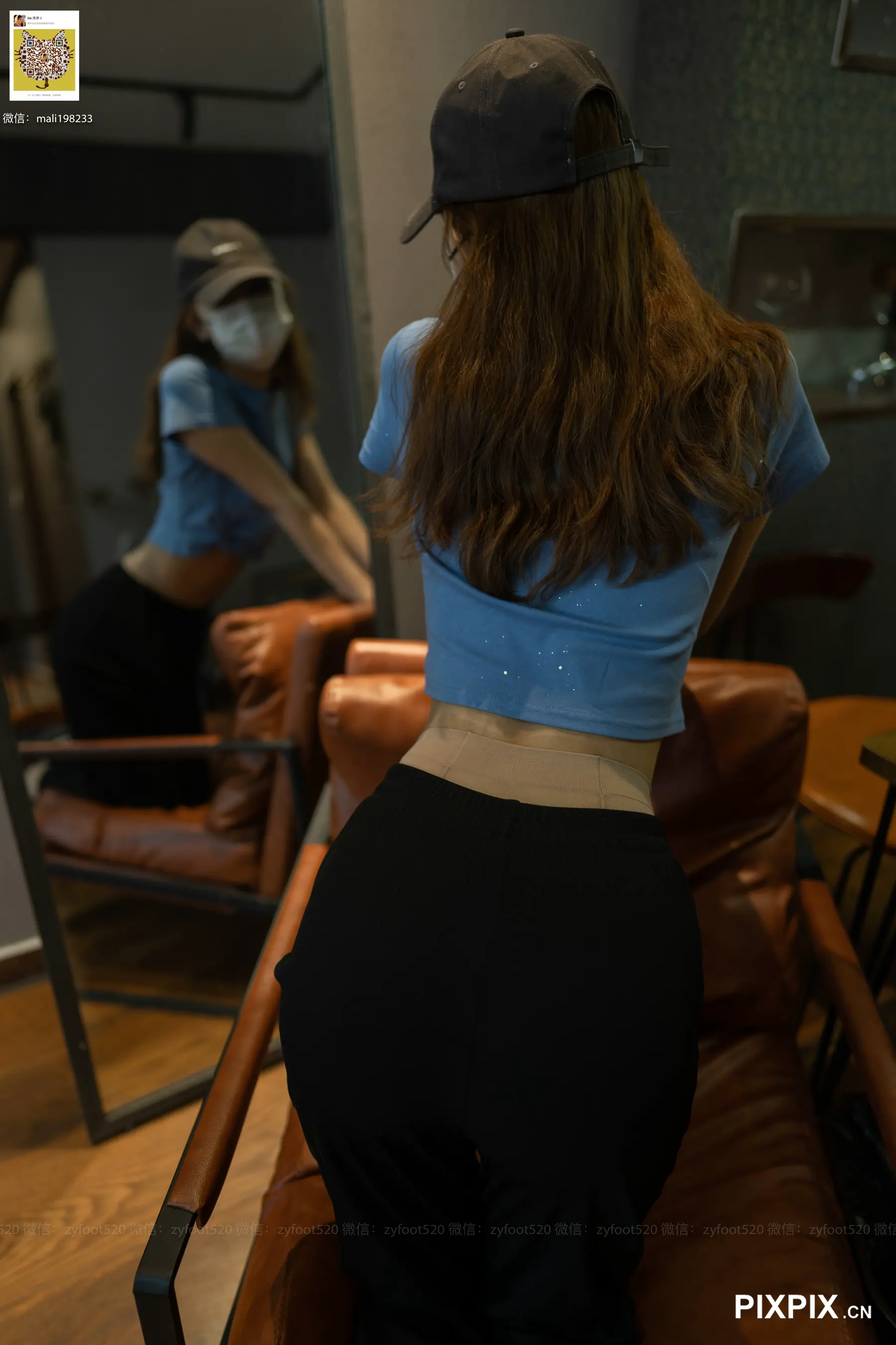 有一位女士戴着棒球帽站在椅子上