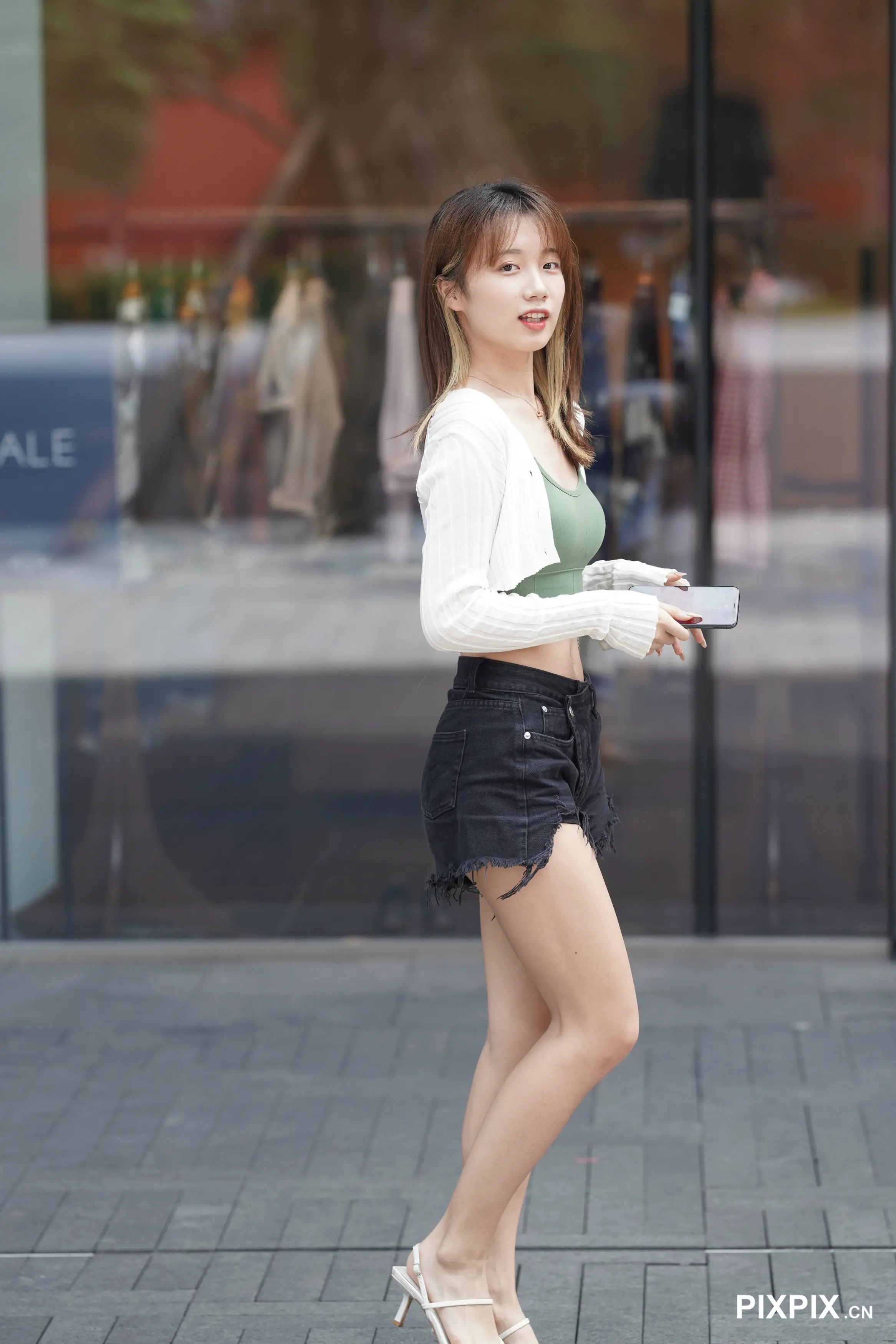 穿着短裙和高跟鞋的亚洲女人走在街上