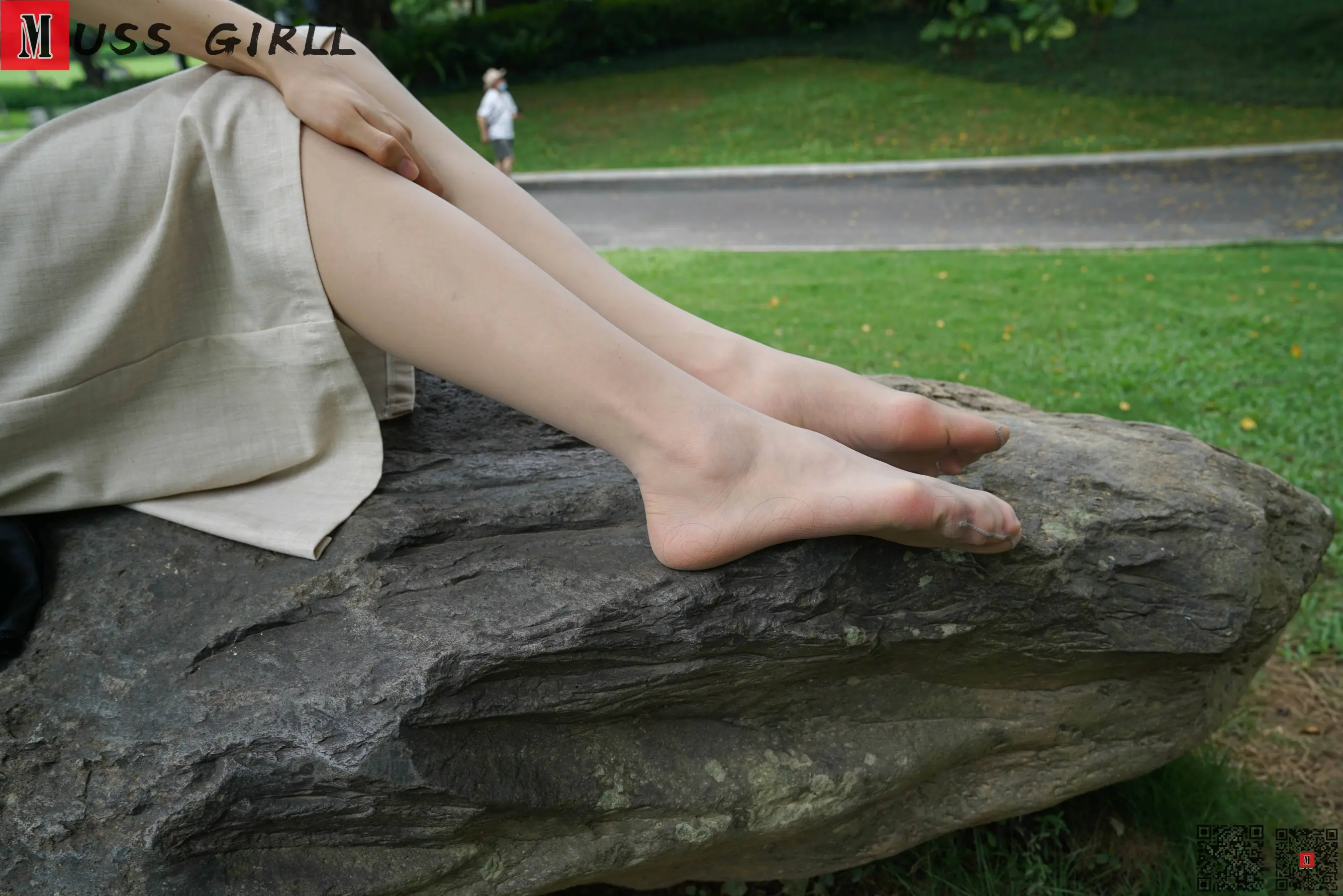 有一个女人盘着双腿坐在岩石上
