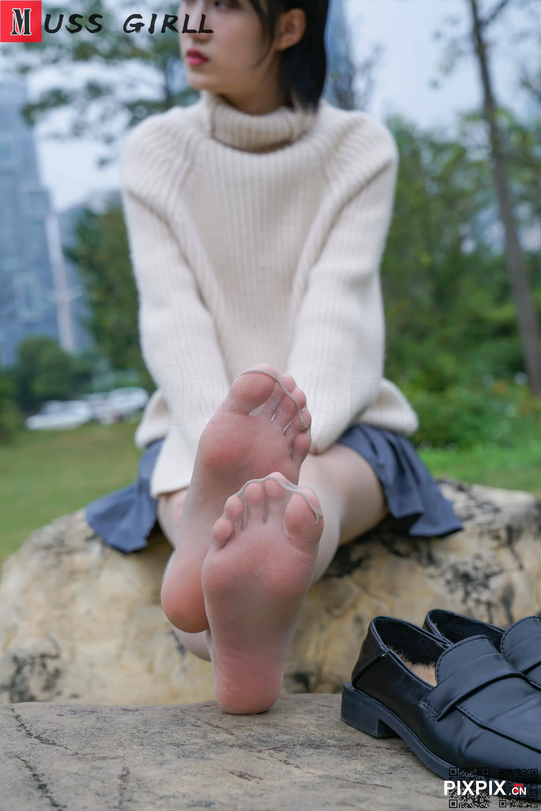 坐在岩石上的女人，双脚抬起